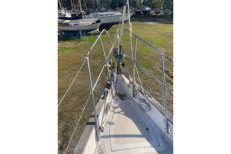 Slide: The Image of 1984 Morgan 384 sailboat deck with railing, docked on grassy area. - 6
