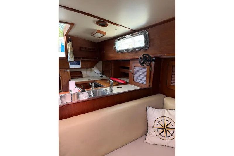 Slide: The Image of Interior of 1984 Morgan 384 sailboat with wooden cabinetry and cozy seating area. - 62