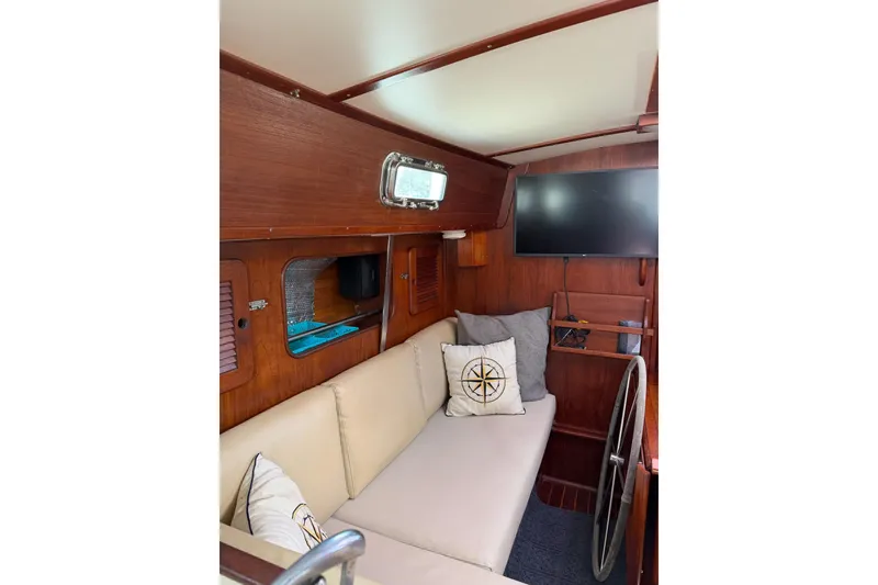 Slide: The Image of 1984 Morgan 384 yacht interior with cozy seating, nautical decor, and a mounted TV. - 67