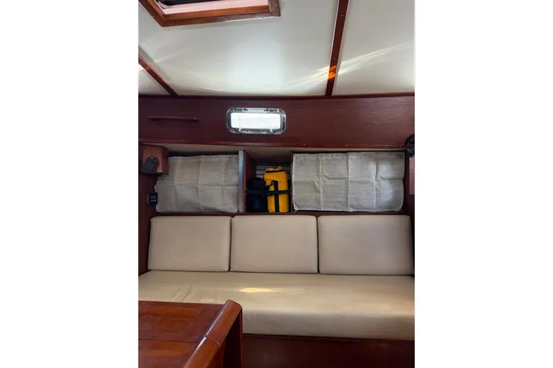 Slide: The Image of Interior of 1984 Morgan 384 sailboat with cushioned seating and storage compartments. - 73