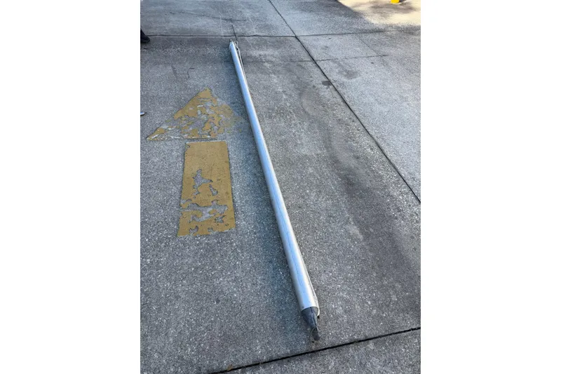 Slide: The Image of Long metal pole on concrete with faded yellow arrow markings. - 74