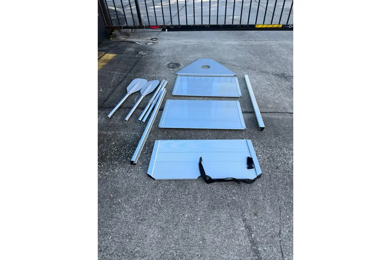 Slide: The Image of Disassembled parts of a 1984 Morgan 384 boat on concrete surface. - 85