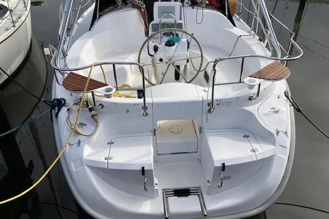 Slide: The Image of Hunter 380 sailboat cockpit, 2000 model, featuring steering wheel and seating, docked at marina. - 1