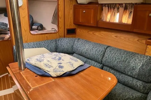 Slide: The Image of Interior of a 2000 Hunter 380 sailboat with cozy seating and wooden finishes. - 11