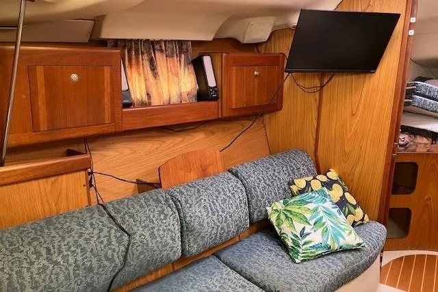 Slide: The Image of Cozy interior of 2000 Hunter 380 sailboat with wood paneling and patterned cushions. - 12