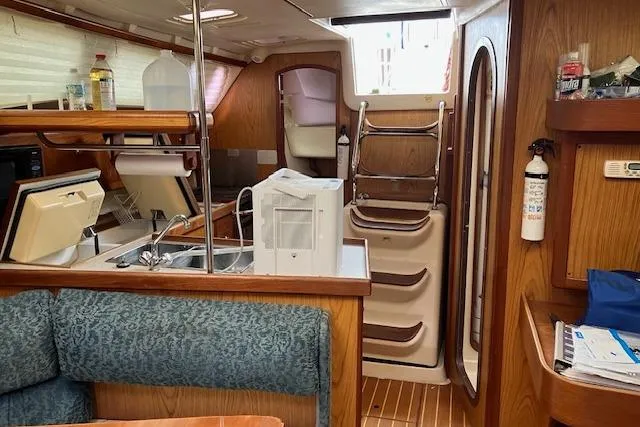 Slide: The Image of Interior of a 2000 Hunter 380 sailboat with kitchen and seating area. - 14