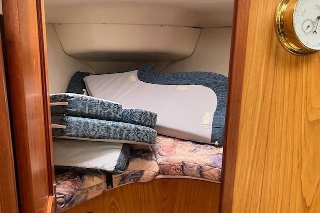 Slide: The Image of Interior cabin of 2000 Hunter 380 sailboat with stacked cushions and wooden paneling. - 17