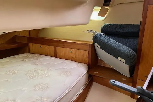 Slide: The Image of Interior cabin of a 2000 Hunter 380 sailboat with a cozy bed and wooden storage. - 18