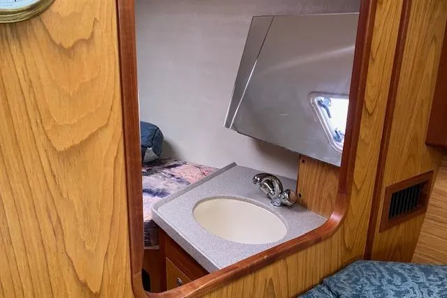 Slide: The Image of Interior of 2000 Hunter 380 sailboat with wooden cabinetry and compact sink area. - 19