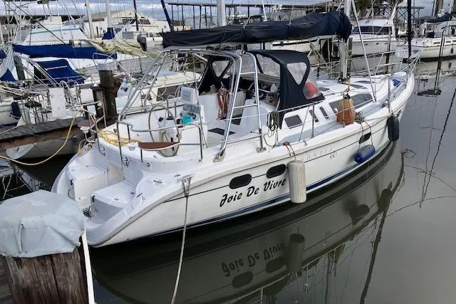 Slide: The Image of 2000 Hunter 380 sailboat named "Joie De Vivre" docked in a marina. - 2