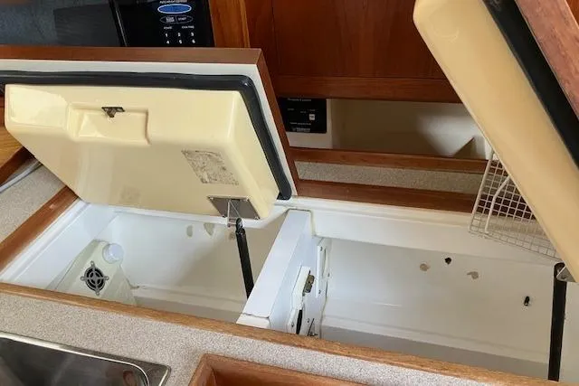 Slide: The Image of Open refrigerator in 2000 Hunter 380 yacht kitchen, showcasing storage space and interior design. - 22
