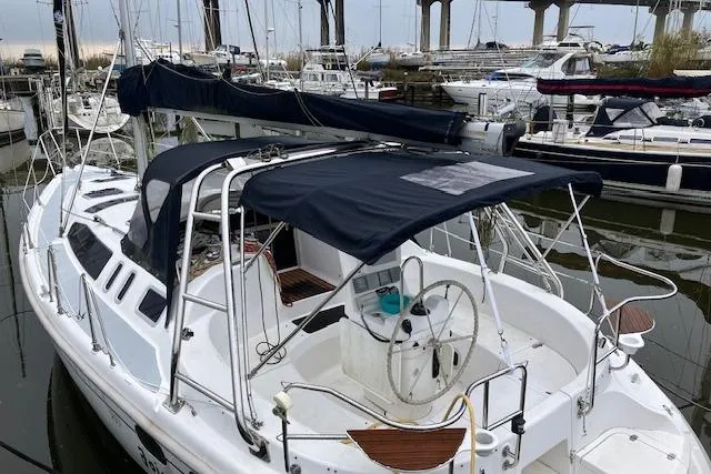 Slide: The Image of Sailboat Hunter 380, 2000 model, docked in a marina with covered cockpit. - 3
