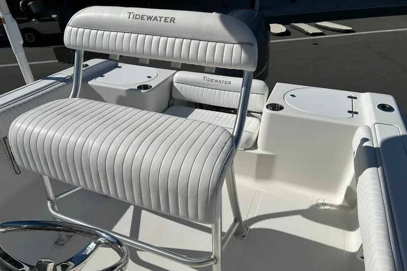 Slide: The Image of 2008 Tidewater 216 CC Adventure boat interior with white cushioned seating and steering wheel. - 12