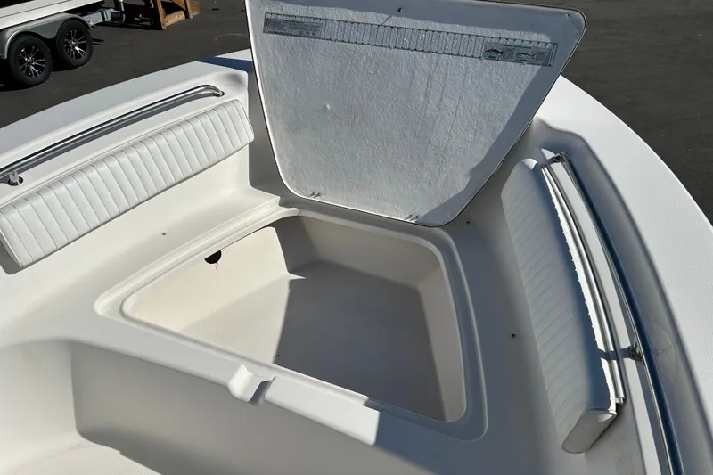 Slide: The Image of 2008 Tidewater 216 CC Adventure boat with open storage compartment and cushioned seating. - 13