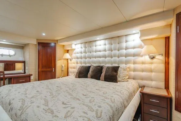 Slide: The Image of Luxurious bedroom interior of 1998 Pacific Mariner 65 yacht with plush bedding and elegant decor. - 13