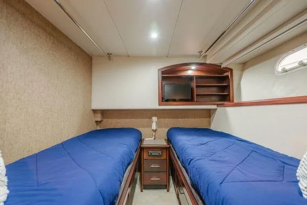 Slide: The Image of Twin beds in a 1998 Pacific Mariner 65 yacht cabin with TV and storage. - 20