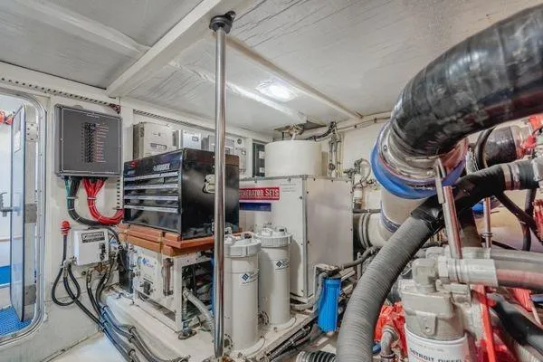 Slide: The Image of Engine room of a 1998 Pacific Mariner 65 yacht, featuring mechanical equipment and control panels. - 32
