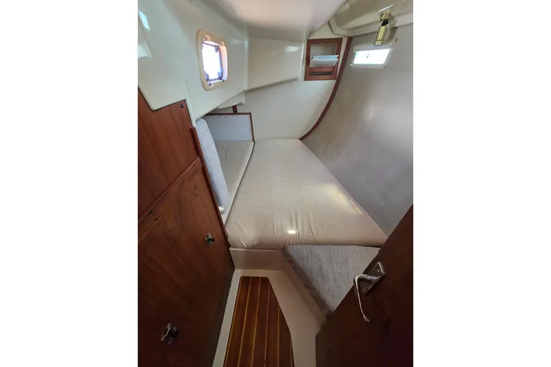 Slide: The Image of 1993 Hunter Legend 35.5 yacht cabin interior with wooden accents and cozy bedding. - 19