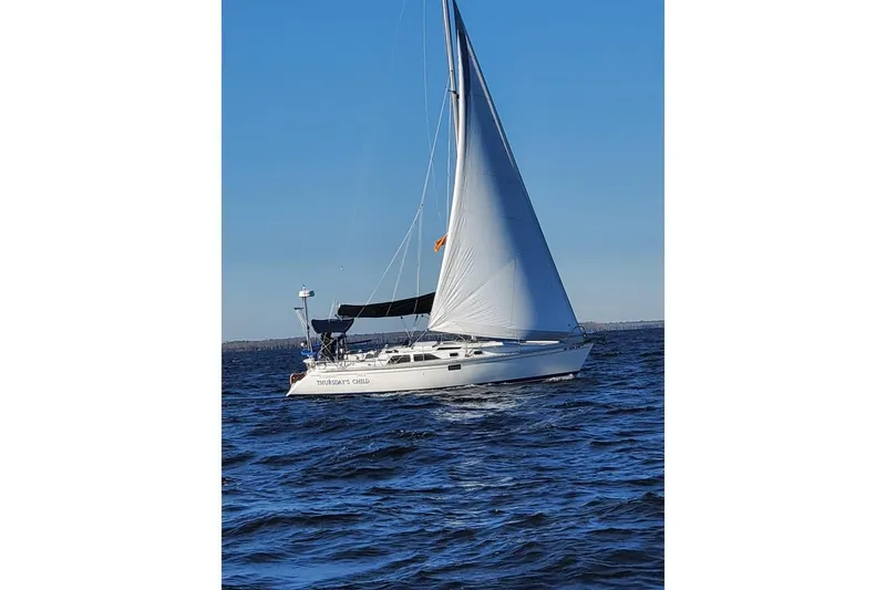 Slide: The Image of Sailboat Hunter Legend 35.5, 1993 model, sailing on open water under clear blue sky. - 31