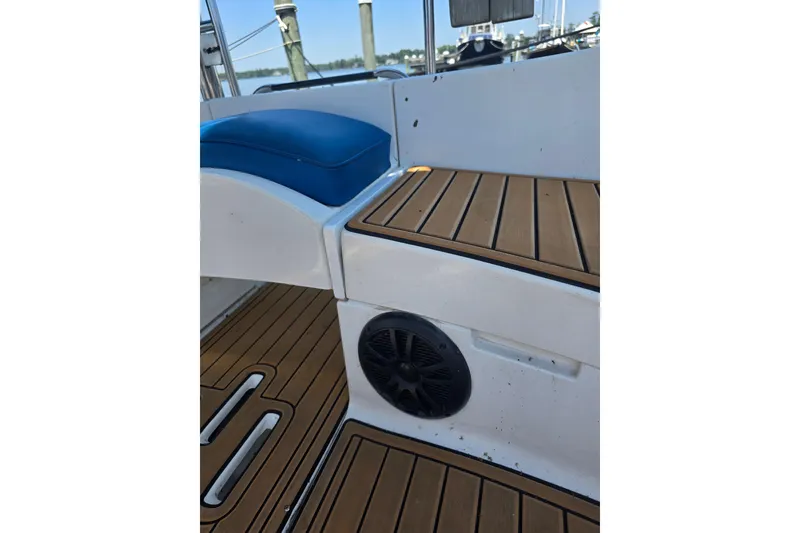 Slide: The Image of 1993 Hunter Legend 35.5 sailboat cockpit with teak flooring and blue cushioned seating. - 33