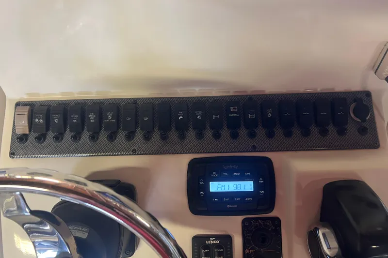 Slide: The Image of Control panel of a 2016 Carolina Skiff 23 Ultra Elite boat with switches and radio display. - 18