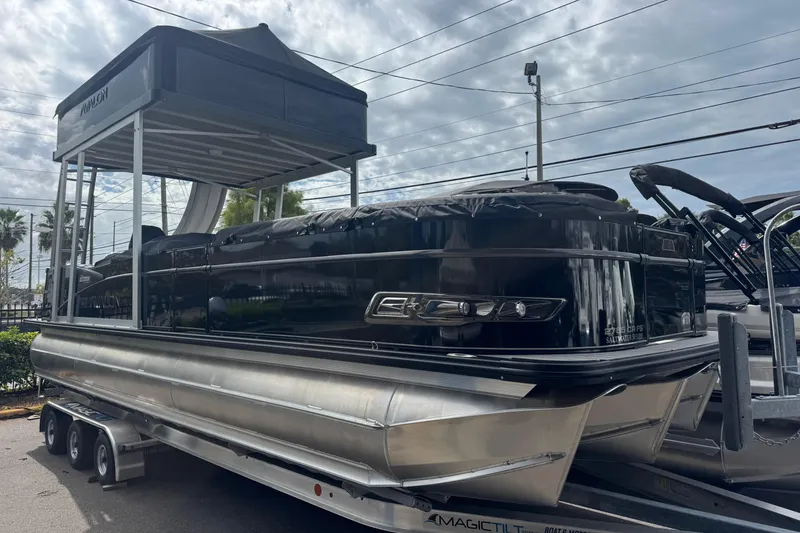 The Image of 2026 Avalon Catalina Cruise Funship 27' pontoon boat on trailer, under cloudy sky. - 1