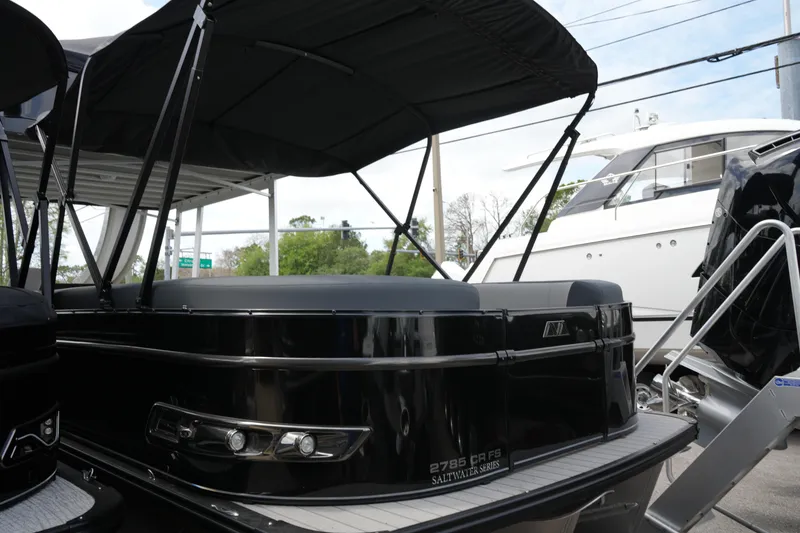 Slide: The Image of 2026 Avalon Catalina Cruise Funship 27' pontoon boat with canopy, docked beside other boats. - 7