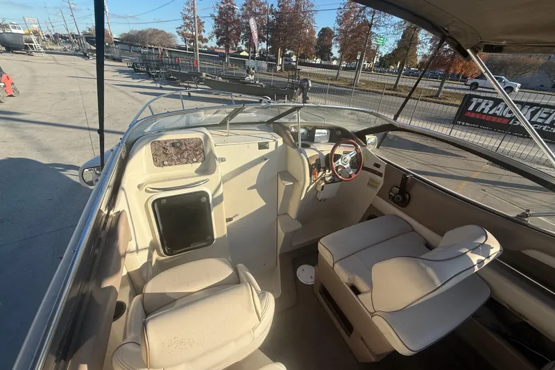 Slide: The Image of 1998 Regal 2250 LSC boat interior with beige seating and steering wheel, parked outdoors. - 13