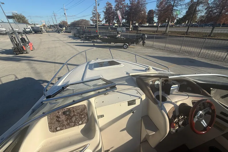 Slide: The Image of 1998 Regal 2250 LSC boat interior with steering wheel, docked outdoors. - 14