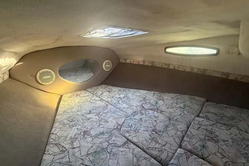 Slide: The Image of 1998 Regal 2250 LSC cabin interior with patterned upholstery and oval windows. - 19