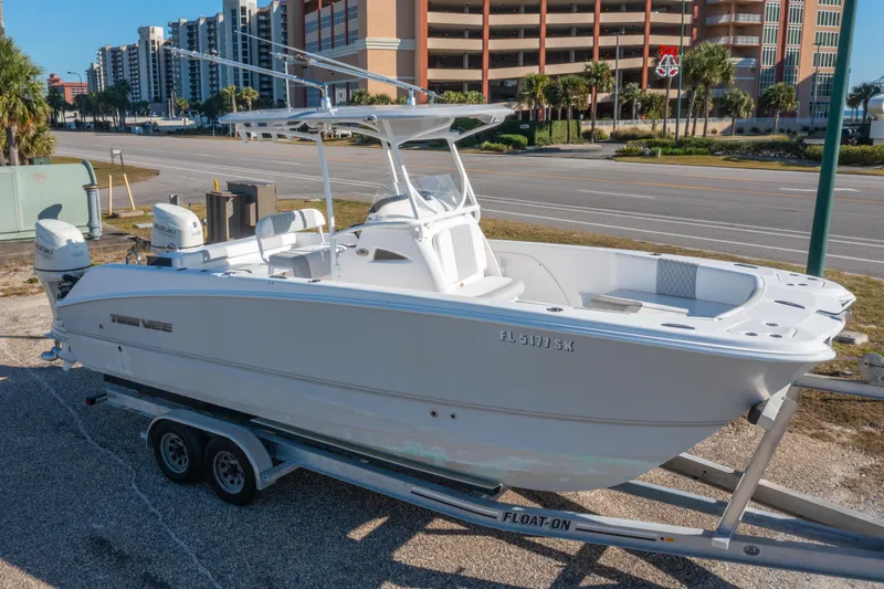 The Image of 2020 Twin Vee 240 GFX CC boat on trailer, parked near a road with buildings. - 0