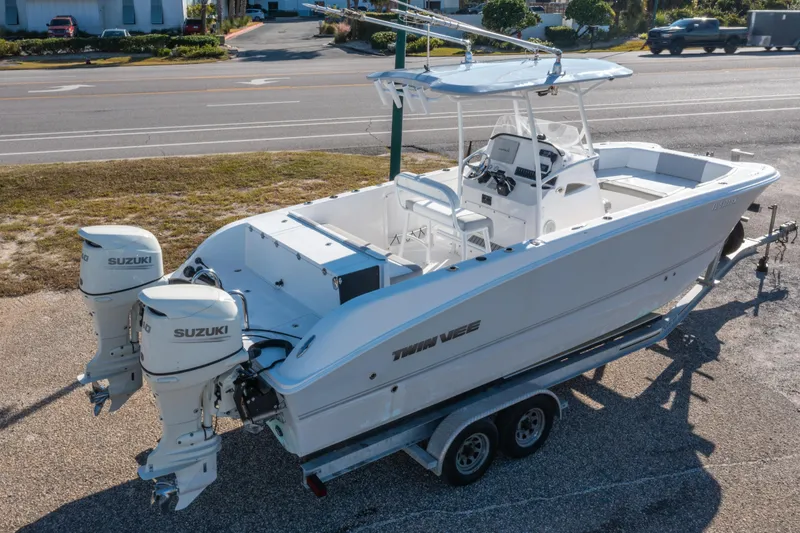 Slide: The Image of 2020 Twin Vee 240 GFX CC boat with dual Suzuki engines on a trailer. - 1