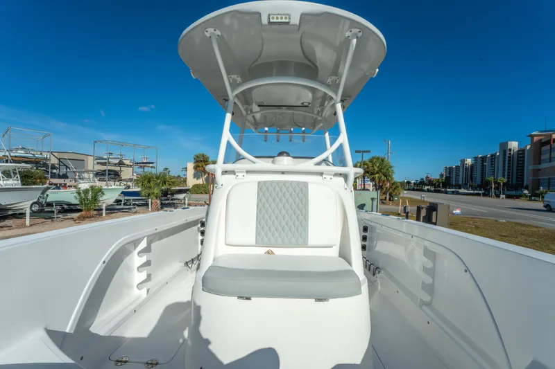 Slide: The Image of 2020 Twin Vee 240 GFX CC boat interior with seating and T-top under clear blue sky. - 37