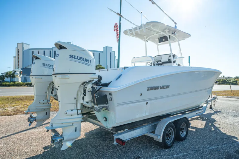 Slide: The Image of 2020 Twin Vee 240 GFX CC boat with dual Suzuki engines on a trailer. - 7
