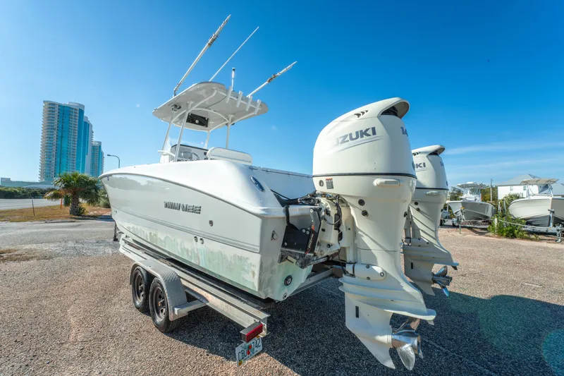 Slide: The Image of 2020 Twin Vee 240 GFX CC boat with Suzuki engines on trailer, urban backdrop. - 8