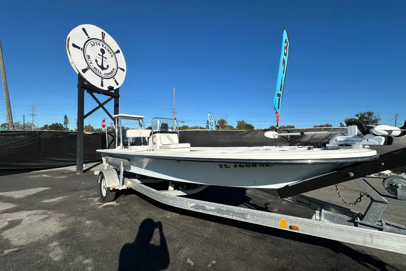 The Image of 2013 Spyder FX17 Flicker boat on trailer at dealership under clear blue sky. - 0