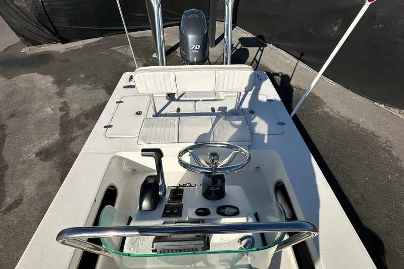 Slide: The Image of 2013 Spyder FX17 Flicker boat with steering console and seating, parked on pavement. - 30