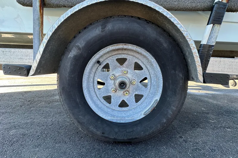 Slide: The Image of Trailer wheel of a 2013 Spyder FX17 Flicker on asphalt surface. - 37