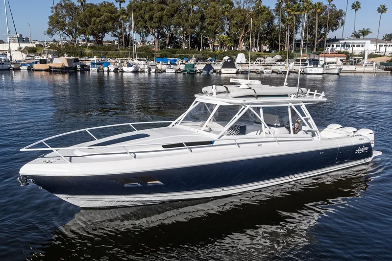 The Image of 2016 Intrepid 400 Cuddy boat cruising in a marina with trees and docks in the background. - 0