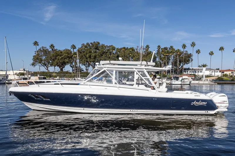 Slide: The Image of 2016 Intrepid 400 Cuddy boat on calm water, with palm trees in the background. - 10