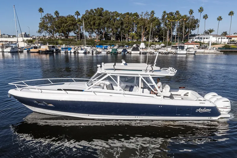 Slide: The Image of 2016 Intrepid 400 Cuddy boat cruising in a marina with palm trees in the background. - 11