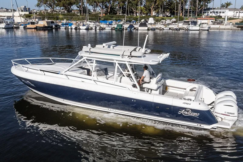 Slide: The Image of 2016 Intrepid 400 Cuddy boat cruising on a calm marina with multiple engines. - 12