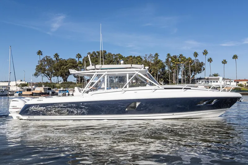 Slide: The Image of 2016 Intrepid 400 Cuddy boat cruising on water, surrounded by palm trees. - 13