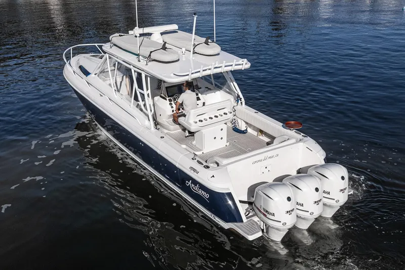 Slide: The Image of 2016 Intrepid 400 Cuddy boat with triple Yamaha engines on calm water. - 2