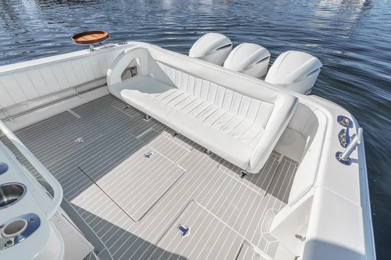 Slide: The Image of 2016 Intrepid 400 Cuddy boat interior with white seating and triple outboard engines. - 23