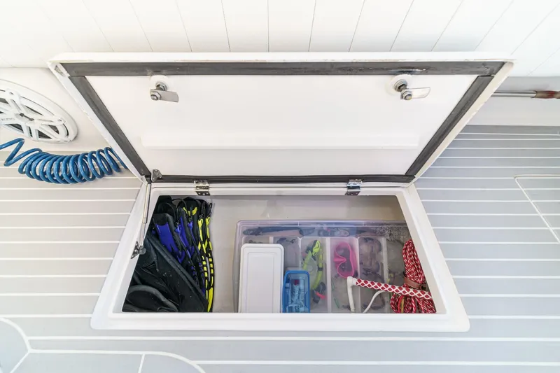 Slide: The Image of Storage compartment on 2016 Intrepid 400 Cuddy boat, containing diving gear and accessories. - 27