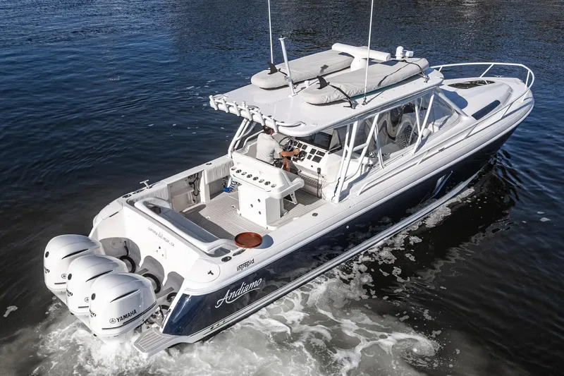 Slide: The Image of 2016 Intrepid 400 Cuddy boat cruising on water with triple Yamaha engines. - 3