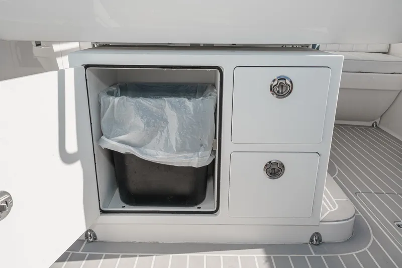 Slide: The Image of Storage compartment on a 2016 Intrepid 400 Cuddy boat with trash bin and drawers. - 31