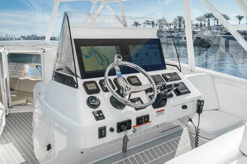 Slide: The Image of 2016 Intrepid 400 Cuddy helm with navigation screens and steering wheel, docked at marina. - 33