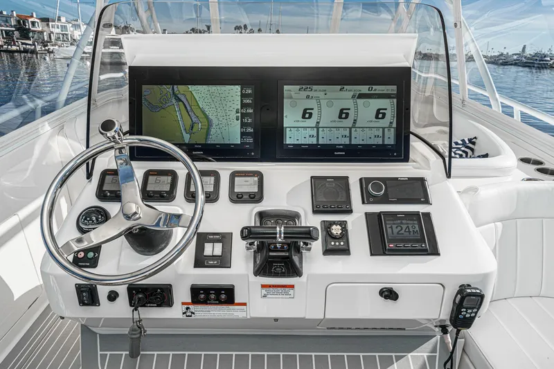 Slide: The Image of Control panel of a 2016 Intrepid 400 Cuddy boat with navigation screens and steering wheel. - 35